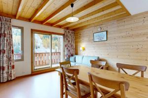 un salon avec une table, des chaises et un canapé dans l'établissement Les Arolles - La Plagne 1800, à La Plagne Tarentaise
