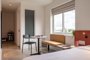 een hotelkamer met een bed, een tafel en een stoel bij COMMON INN Thu Dau Mot in Ga Phú Văn +59 foto's