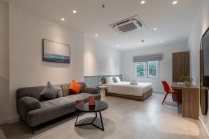 een woonkamer met een bank en een bed bij COMMON INN Thu Dau Mot in Ga Phú Văn