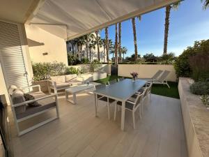 een terras met een tafel, stoelen en een parasol bij Luxury 2 bed apartment in Las Colinas in Orihuela-Costa