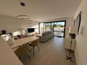 een woonkamer met een tafel, stoelen en een bank bij Luxury 2 bed apartment in Las Colinas in Orihuela-Costa