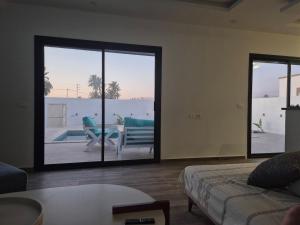 a living room with a couch and a patio with a table at Villa Midoun in Midoun