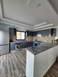 a large kitchen with black cabinets and a counter top at Villa Midoun in Midoun +7 photos