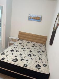 Schlafzimmer mit einem Bett mit einer schwarzen und weißen Tagesdecke in der Unterkunft Casa de Férias no Sôssego in Itamaracá