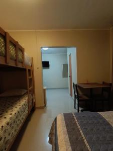 ein Schlafzimmer mit einem Etagenbett, einem Tisch und einem Schreibtisch in der Unterkunft HOSPEDAJE JOSUE - paracas in Paracas