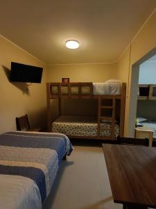 a bedroom with two bunk beds and a television at HOSPEDAJE JOSUE - paracas in Paracas