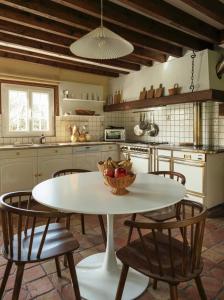 eine Küche mit einem Tisch mit einer Obstschale darauf in der Unterkunft Harmony Homes Le Cottage Bleu - Indoor Pool Sauna & Spa in Le Planquay
