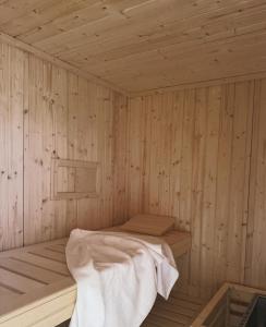 ein Holzzimmer mit einem Bett in einer Sauna in der Unterkunft Harmony Homes Le Cottage Bleu - Indoor Pool Sauna & Spa in Le Planquay
