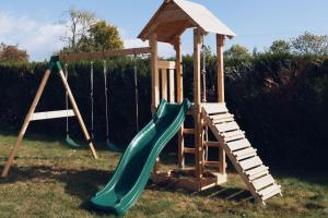 einen Spielplatz mit Rutsche und Holzkonstruktion in der Unterkunft Harmony Homes Le Cottage Bleu - Indoor Pool Sauna & Spa in Le Planquay + 23 Fotos