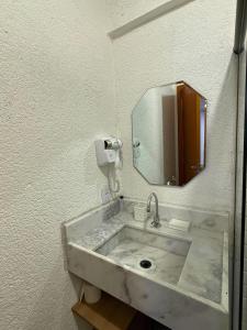 a bathroom with a concrete sink with a mirror at MHV Milagres - Studio Guadalupe 11 in Passo de Camarajibe