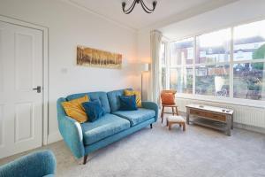 ein Wohnzimmer mit einem blauen Sofa und einem Fenster in der Unterkunft Host & Stay - Prospect Retreat in Knaresborough + 16 Fotos