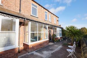 ein Backsteinhaus mit einem Fenster und einem weißen Stuhl in der Unterkunft Host & Stay - Prospect Retreat in Knaresborough
