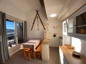 a small kitchen with a table and a window at Appartement 2P Mezzanine, 2 SDB, 6-7 couchages aux Saisies - FR-1-293-75 in Les Saisies +13 photos