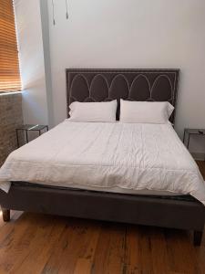 een bed met witte lakens en kussens in een slaapkamer bij Creole Nest in New Orleans