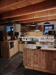 een grote keuken met houten kasten en een groot eiland bij Chalet Al Maso Val Calamento in Telve