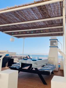 ein Balkon mit einem Tisch und einem Leuchtturm am Strand in der Unterkunft Casa da Praia in Albufeira
