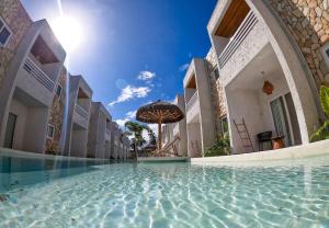 a swimming pool in a building with an umbrella at MHV Milagres - Casa Corais, Curimã D9 in Passo de Camarajibe