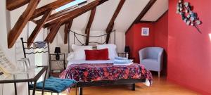 a bedroom with a bed with a red wall at Chambres d'hôtes de Massigoux in Aurillac