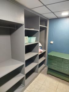 ein begehbarer Kleiderschrank mit grauen Regalen und einem grünen Hocker in der Unterkunft Casa Vistagolfo in La Unión + 7 Fotos