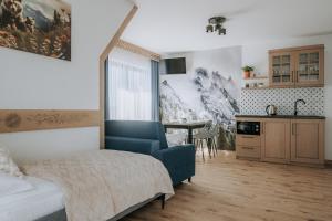 a bedroom with a bed and a kitchen with a table at Willa Janowa & SPA in Bukowina Tatrzańska