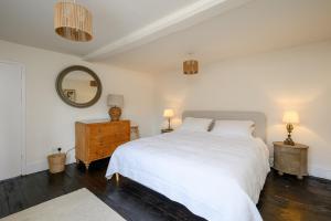a bedroom with a white bed and a mirror at Historic Riverside House - Village, River Walks & Easy York Access in Cawood