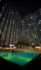 马尼拉Jazz Residences Makati City的一座大型建筑,在晚上前设有一个游泳池