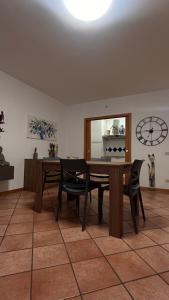 a dining room with a table and chairs and a clock at Alida in Salò