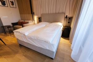 a bedroom with a large bed with white sheets at VacationClub - Baltic Waves Resort Apartament A109 in Międzyzdroje +10 photos
