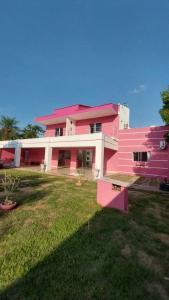a pink building with a yard in front of it at Family Space - Chacara Rosa Beautiful and Comfortable in Cuiabá +11 photos