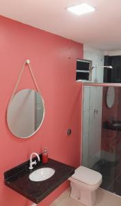 ein Badezimmer mit Waschbecken, Toilette und Spiegel in der Unterkunft Family Space - Chacara Rosa Beautiful and Comfortable in Cuiabá