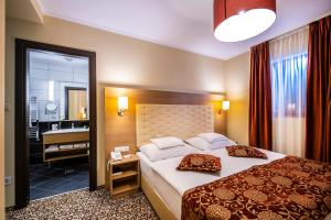 Postel nebo postele na pokoji v ubytování Erdőspuszta Club Hotel Fenyves