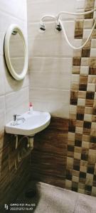 a bathroom with a sink and a mirror at Divine home stays in Madikeri