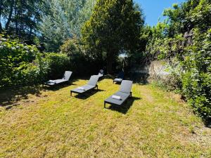 un gruppo di panchine sedute nell’erba di Cottage Wisteria a Prasco