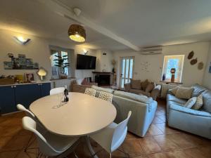 un soggiorno con un tavolo e un divano di Cottage Wisteria a Prasco