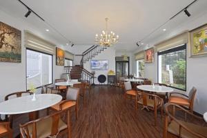a dining room with tables and chairs and a chandelier at Dalat Villaa in Da Lat