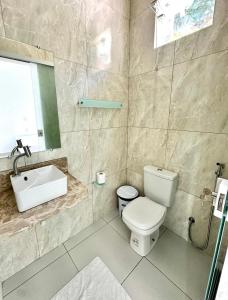 a bathroom with a white toilet and a sink at Mambo beach gamboa in Cayru