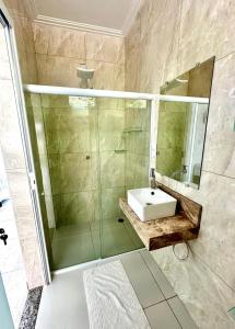 a bathroom with a sink and a glass shower at Mambo beach gamboa in Cayru