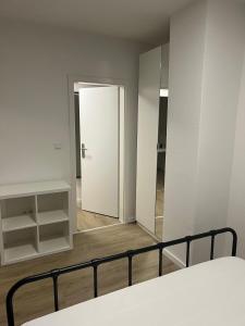 ein weißes Zimmer mit einem Bett und einem Spiegel in der Unterkunft Apartment in einem ehemaligen Hotel in Stuttgart + 5 Fotos