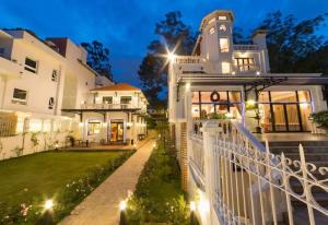 a large white house with a white fence at Dalat Villaa in Da Lat