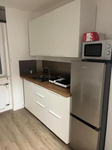 eine Küche mit Kühlschrank und Mikrowelle in der Unterkunft Apartment in einem ehemaligen Hotel in Stuttgart