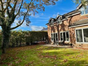 a brick house with a lawn and a tree at Luxury 5 Bedroom House near York - Escrick in Escrick