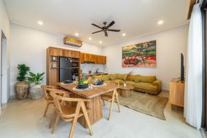 een keuken en woonkamer met een tafel en stoelen bij Walk to the Beach from This Brand New 3BR Villa with Pool! in Sanur