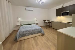 una piccola camera da letto con un letto e una cucina di Chorus Home a Bergamo