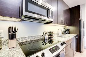 una cocina con estufa y microondas en 1BR Stylish Apartment With Rooftop Deck & Pool, en Baltimore