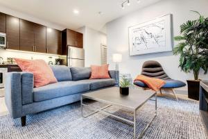 Una sala de estar con un sofá azul y una mesa. en 1BR Stylish Apartment With Rooftop Deck & Pool, en Baltimore