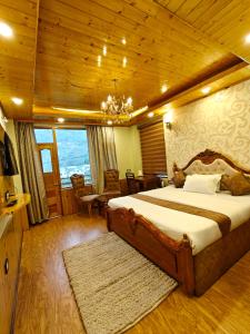 a bedroom with a large bed with a wooden ceiling at Shasha in Manāli
