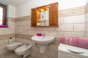 une salle de bain avec un lavabo, des toilettes et un miroir dans l'établissement Casa Pietro, à San Teodoro 24 autres photos