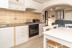 une cuisine avec des armoires blanches et un comptoir dans l'établissement Casa Pietro, à San Teodoro