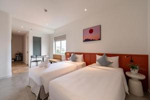 En eller flere senge i et værelse på COMMON INN Thu Dau Mot