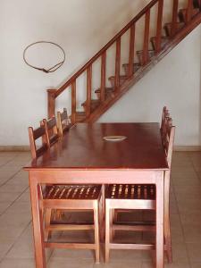 a wooden table with four chairs and a staircase at Baobab Beach Villa in Abene